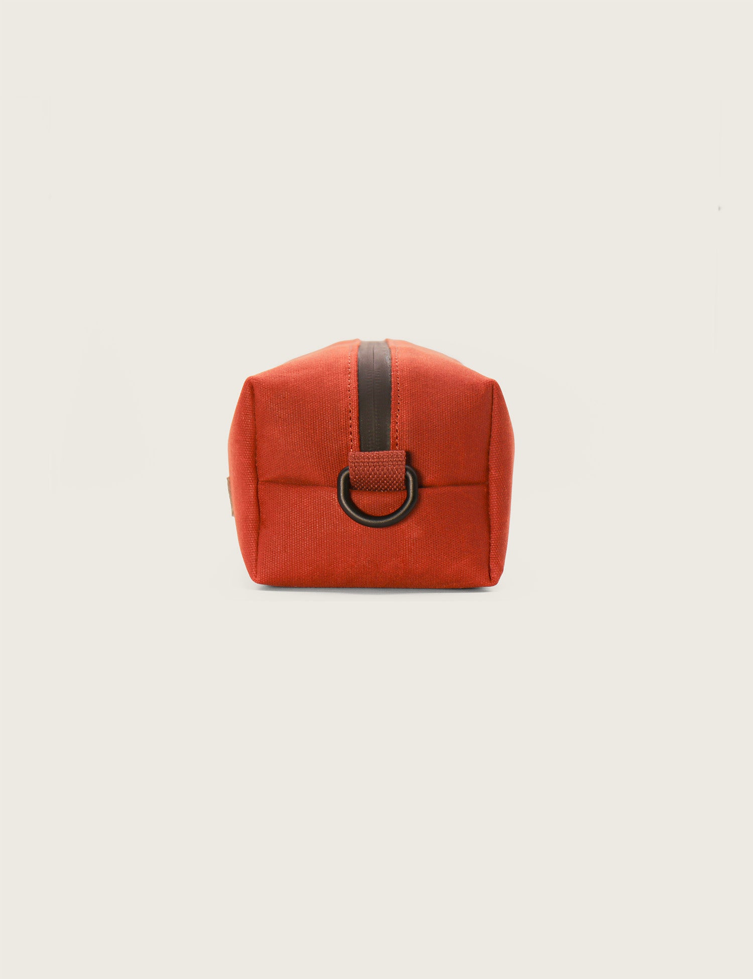 Orange pouch with a black strap on a light beige background
