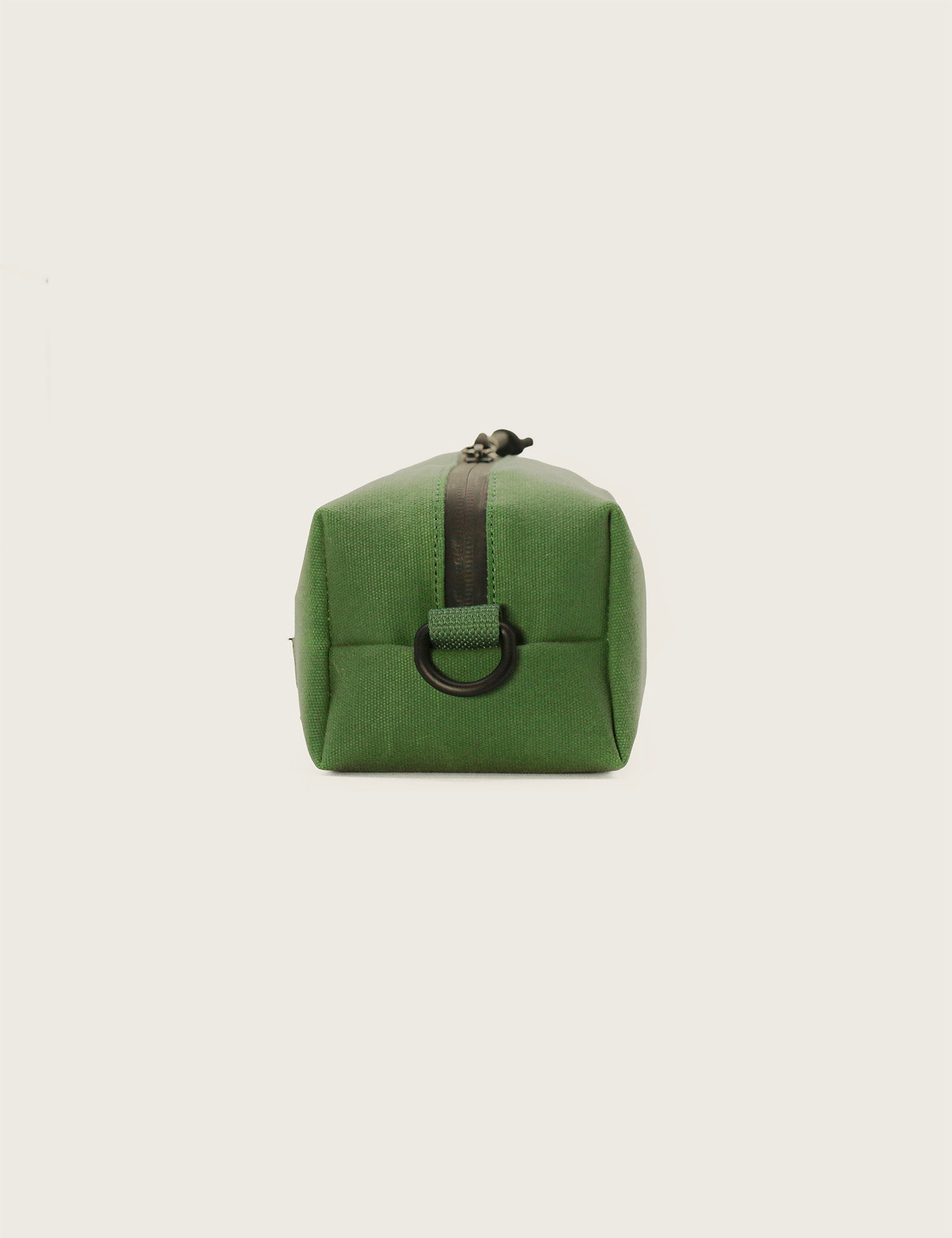 Green toiletry bag with black zipper on a light gray background